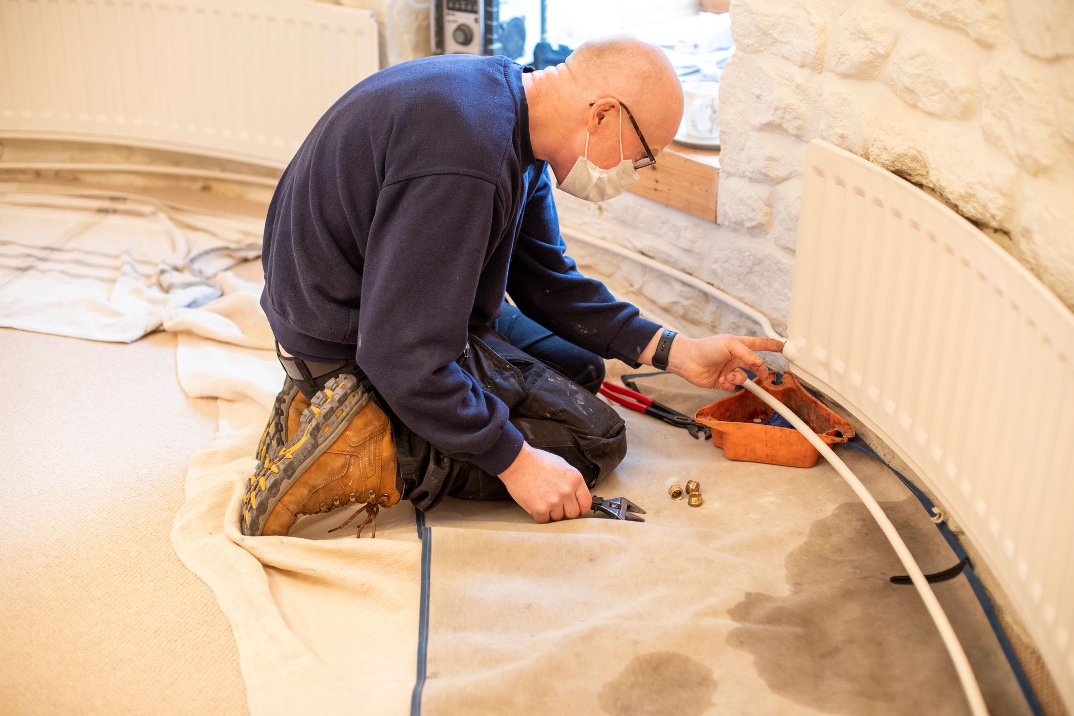Technician adjusting a home heating pipe