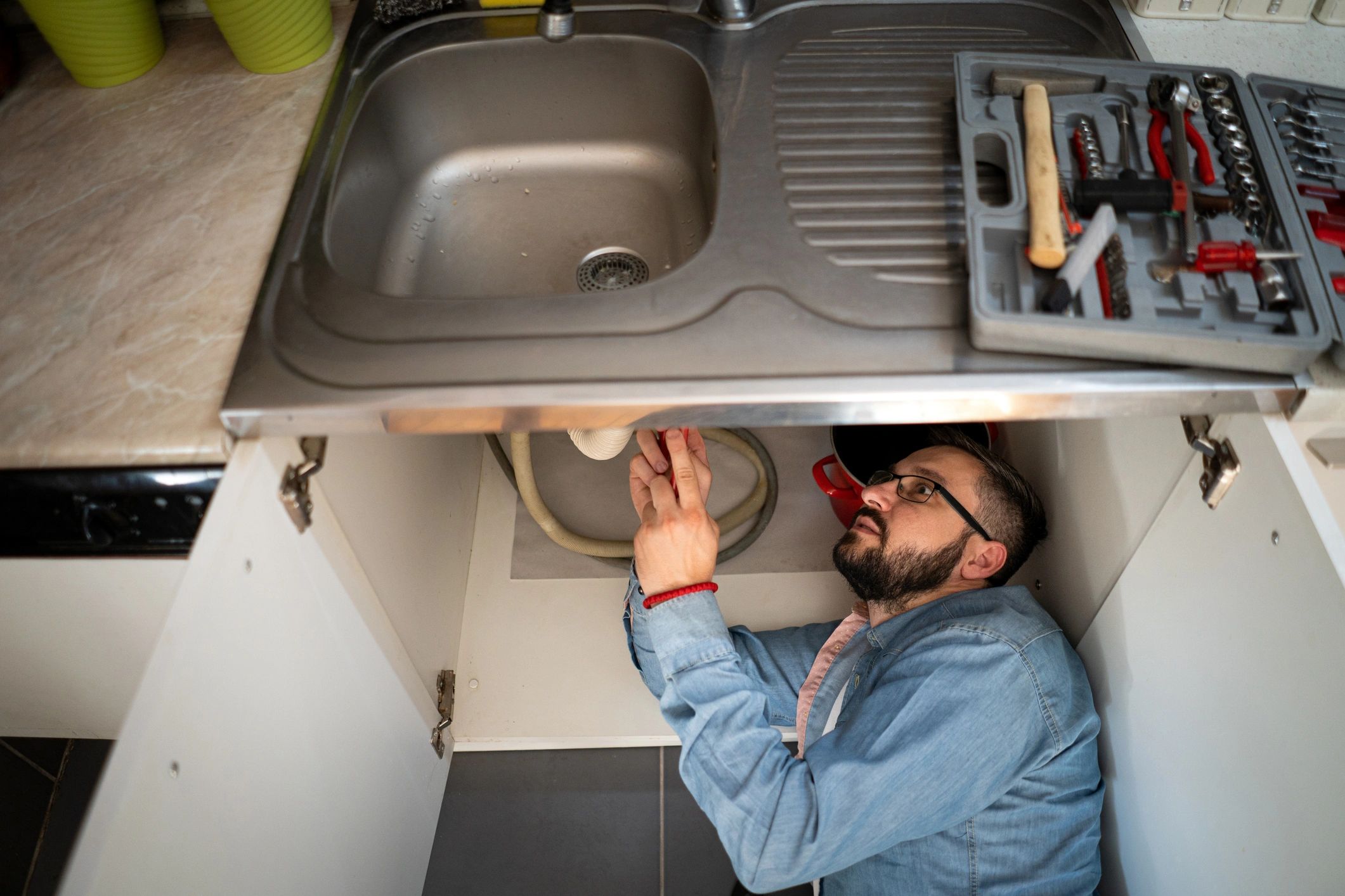 Plumber working on a drain issue in a home