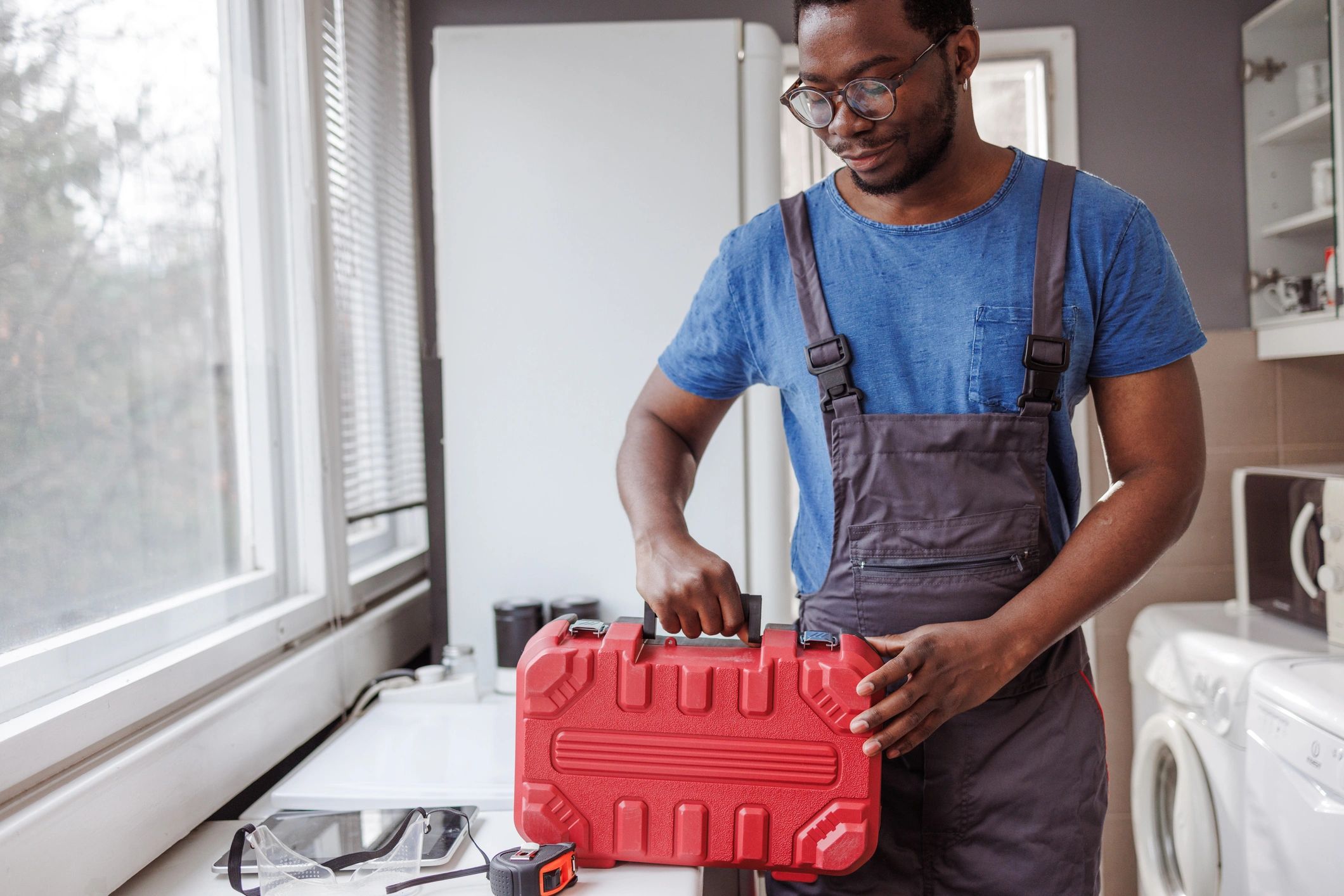 Plumber with toolbox in a kitchen