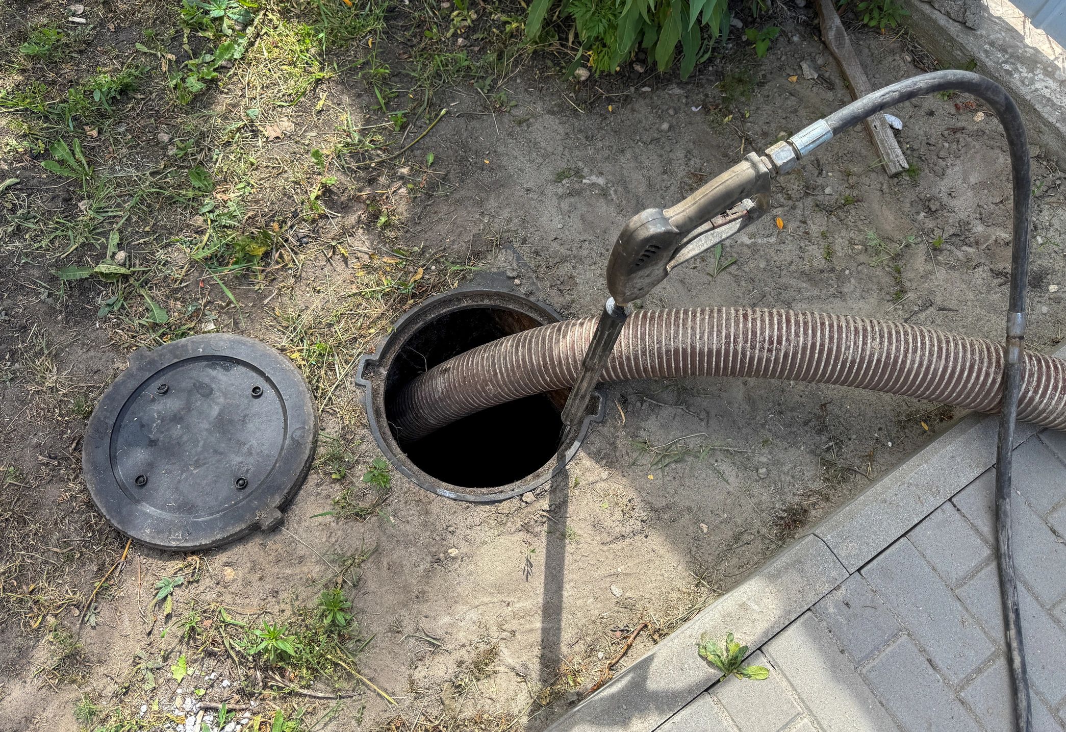 Technician working on a sewer line with a hose