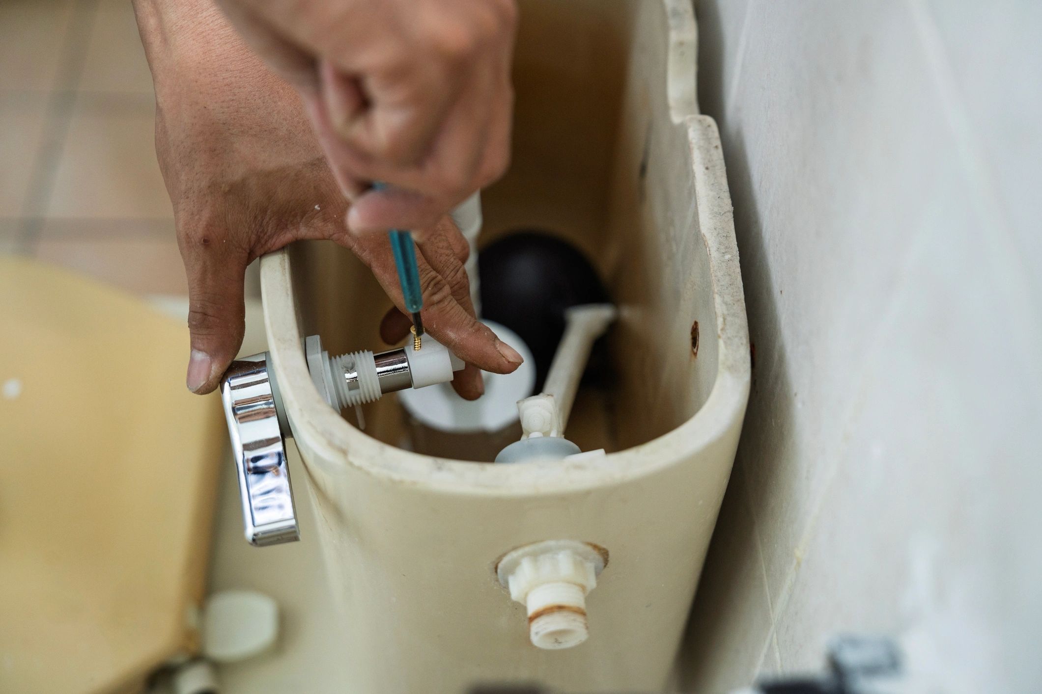 Plumber repairing a toilet flush mechanism