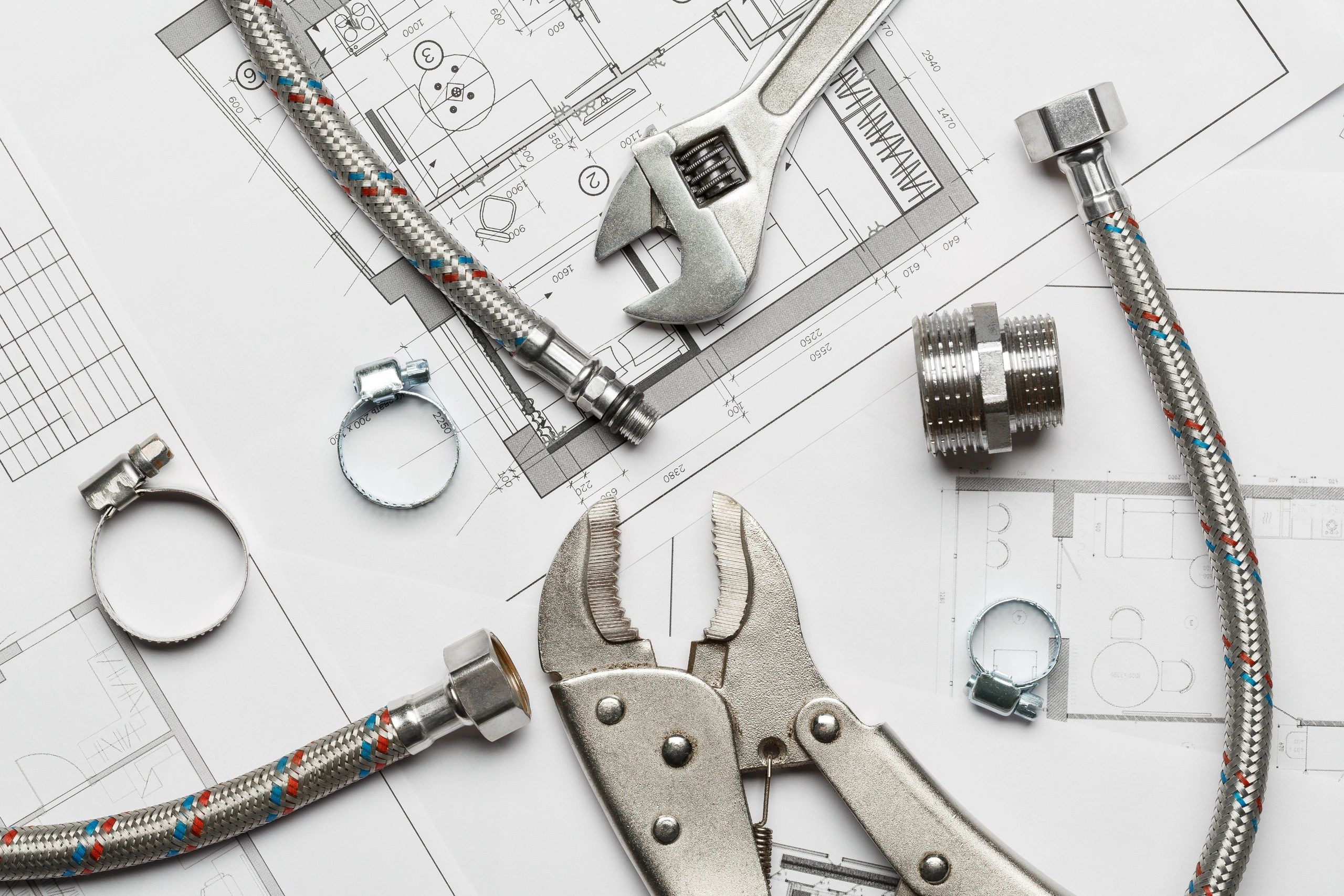 Plumbing tools and parts laid out on building plans